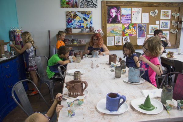 Popelka works with her students on a ceramics project.