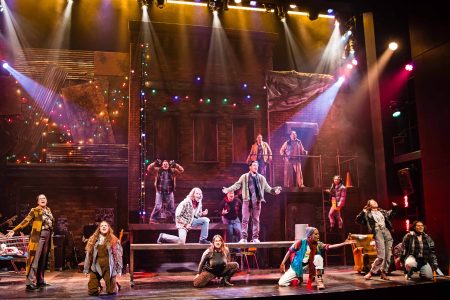 The cast of Rent sings on stage