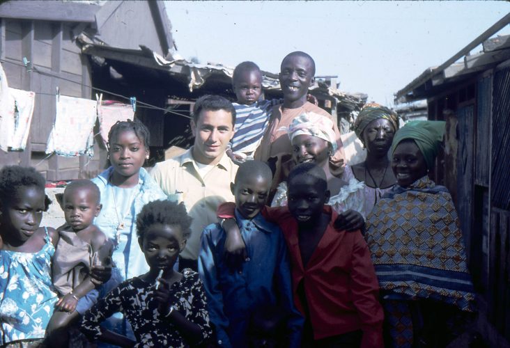 Bill Aossey ’63, center, with the family who lived next door to him in Senegal. He helped teach the children and often ate meals with them. 