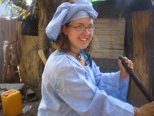 Maggie Rudick Taphouse ’08 helps prepare enough breakfast porridge to serve the entire village in Gambia where her Peace Corps family was holding a naming ceremony for their newborn.