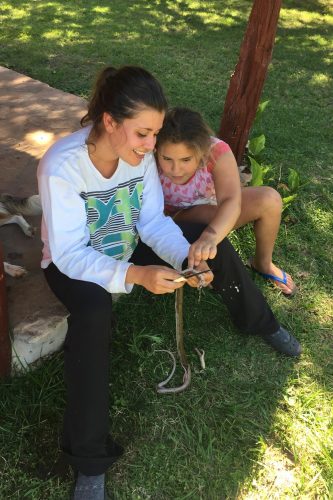 Maria Goodfellow ’16 dissects a snake with a neighbor girl. The nonvenomous snake had been killed by the family, and she used it as a teachable moment.