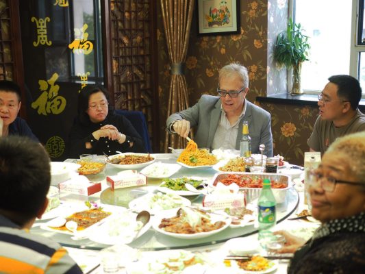 Professor Tony deLaubenfels shares a meal with hosts in China.