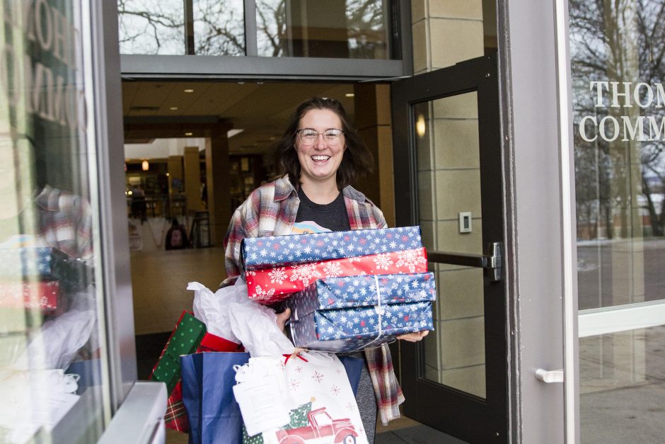 Kaylee Crouse carries gifts to load up into a van