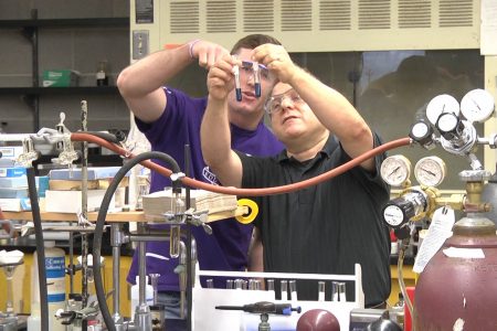 Charley Liberko and Ben Hewson look at test tubes