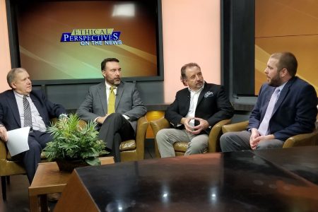 Four people talking on a television set