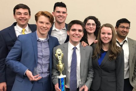 Cornell College Mock Trial Team holds a trophy and smiles for a photo