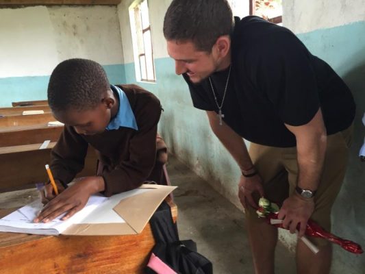 Futrell with a child during the Economic Development in Rural Tanzania class in 2016