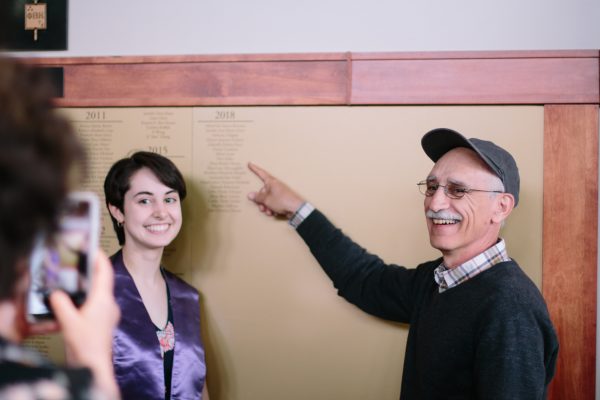 Family looks at name on Phi Beta Kappa plaque.