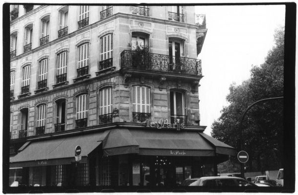 Black and white photo of a building that says le Paris