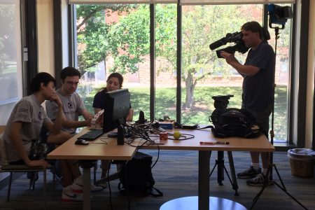 Videographer captures video of students and professor working on summer research