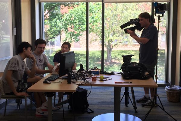 Videographer captures video of students and professor working on summer research