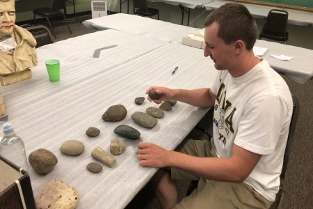 Caleb Blair sorts artifacts from a dig site.