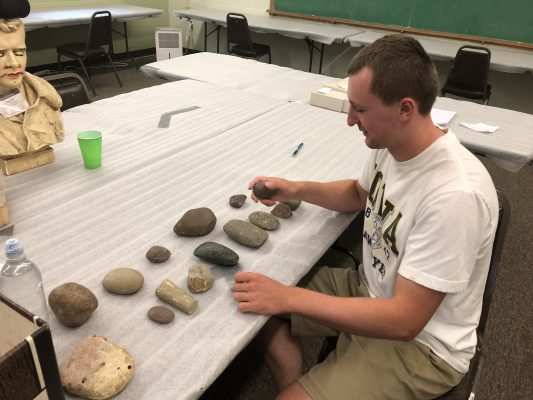 Caleb Blair sorts artifacts from a dig site.