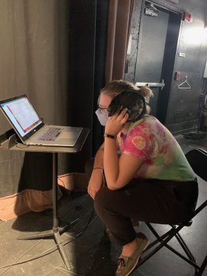 Lead production assistant Elizabeth Koetz listens to studio recordings to monitor for unwanted room noise