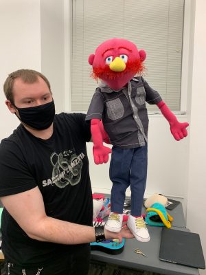 Lead puppet designer shows off his puppet for Pork Tornadoes' keyboardist, Jerry Lorenson.