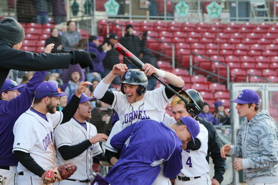 Teammates congratulate team captain Lucas Larson ’19 after scoring a run against rival Coe College in 2018.