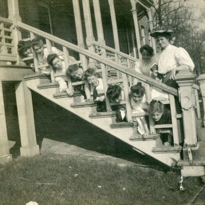 Bowman Hall residents have a little old-fashioned fun on the front porch steps in this undated archival photo.