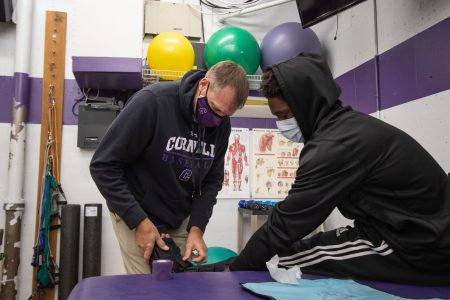 Head Athletic Trainer Loren Nydegger treats football player Demarius Pittman ‘22 in the training room. Photo by Ray Borchert ’24.