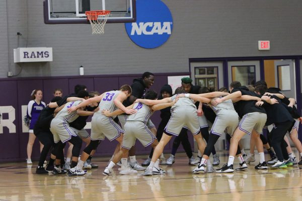 Daniel Burford ’22 (center left inside circle) leads his teammates in a ritual to build spirit prior to a 2020 men’s basketball game in the Small Sport Center. 