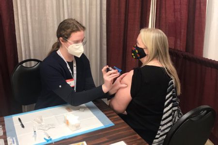Skye McCormick giving the COVID-19 vaccine to a patient