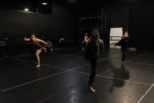 three dancers performing during a rehearsal