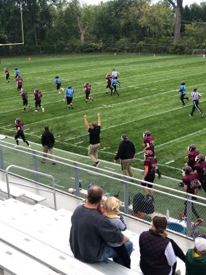  Chapman (center) cheers with his arms in the air right after his team scored a 40-yard touchdown run at home.