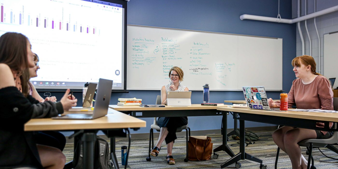 Ringer Distinguished Professor of Sociology Tori Barnes-Brus ’97 talks with her students about their research