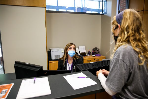 Student stops at the reception desk in the new Welcome Center