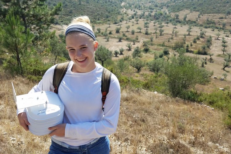 Gabi Hiatt '21 holds data loggers outside a Portuguese cave.