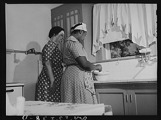 Southern white employers often supervised the work of domestic staff, a practice that domestic workers objected to as it undermined their autonomy and skills. This 1943 photo shows the wife of a wholesale grocer, Mrs. Thomas, in her kitchen with the unidentified woman who was employed as a maid in San Augustine, Texas. Photographer John Vachon, U.S. Farm Security Administration/Office of War Information Photograph Collection. Courtesy: Library of Congress, Prints & Photographs Division, FSA/OWI Collection, LC-USW3-025238-D