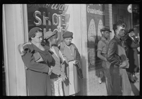 This photo, taken by New Deal photographer Marion Post Wolcott in 1939, shows three domestic workers waiting on Mitchell Street in Atlanta for the morning streetcar that will take them to their workplaces in private households.  Black passengers were routinely discriminated against by white passengers and conductors on segregated streetcars in Atlanta, Georgia, and elsewhere in the South.  Coutesy: Library of Congress, Prints and Photographs Division, Farm Security Administration/Office of War Information Black and white negatives.