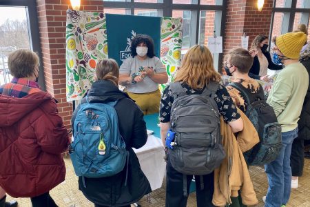 An employer talks with a group of students at the Job & Internship Expo