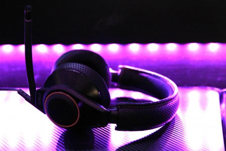 Esports headset on below a monitor with purple lights in the background