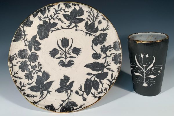 A ceramic cup and plate with floral decorations