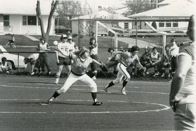 Sarah McCrea ’84 pitches as Carolyn Kingland-Hanson ’86 charges in an early intercollegiate softball game. 