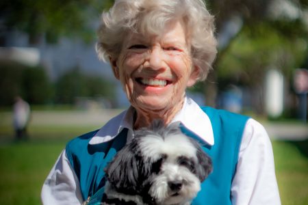 Kathie Adams Meyer '67 stands on the grounds of the Florida Mayo Clinic with her therapy dog Payton.