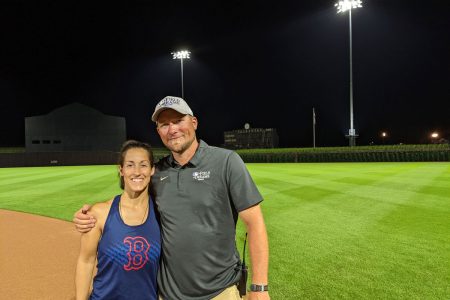 Elizabeth and Kevin Moses ’04 at the Field of Dreams in Dyersville, Iowa. Moses collects baseball hats (his Field of Dreams hat pictured in the photo) from the ballparks he works on.