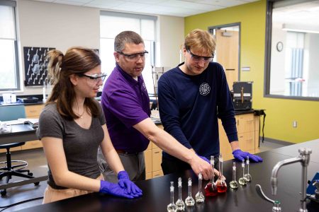 Professor of Chemistry Craig Teague works with Arianna Jewell and Dane Markegard.