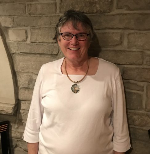 Georgia Yanicke '67 smiling in white blouse and necklace