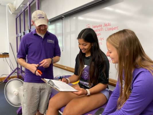 Assistant Professor of Kinesiology Justus Hallam works with Ilah Perez-Johnson (middle) and Caitlin Babcock. 