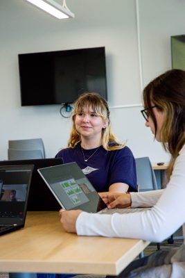 Two students sit by computers