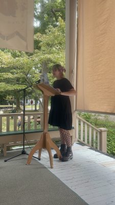 Becca Gutierrez reads from a podium at a microphone on a stage