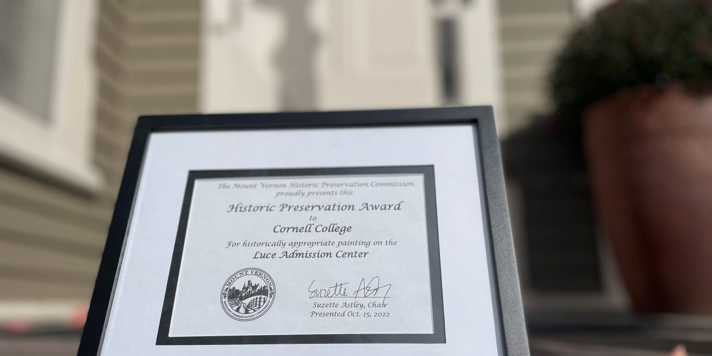 Picture of a framed award on the steps of Luce House.