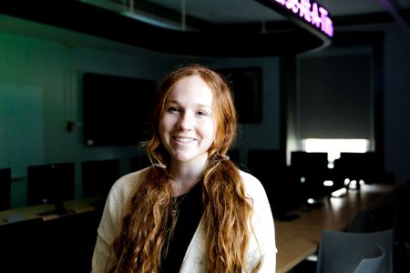 Abby Patten ’23 stands in the Don Cell Finance Lab, which simulates an investment trading floor within McLennan College Hall.