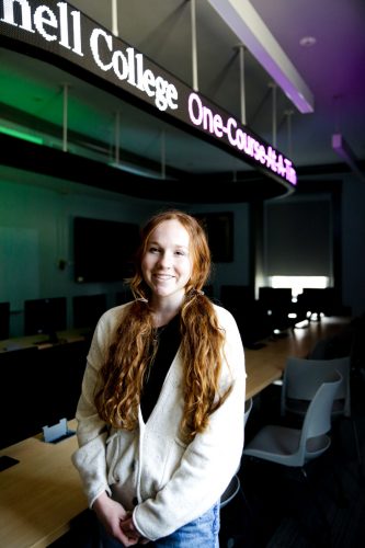 Abby Patten ’23 stands in the Don Cell Finance Lab, which simulates an investment trading floor within McLennan College Hall.