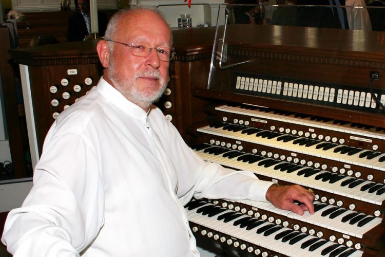 Bruce R. Eicher ’54 seated at the organ