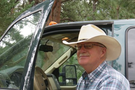 Don MacDonald ’67 in cowboy hat emerging from a truck