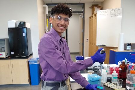 Jonathan Azenon '24 smiles while using a piper in Russell Science Center