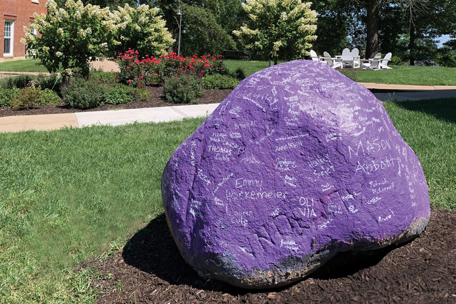 The Rock is purple with white names painted on it