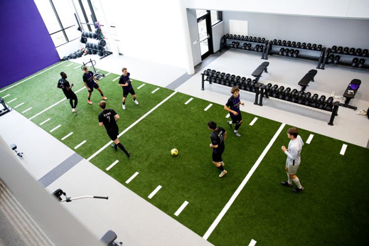 men's soccer players practice on the SAW turf area, as seen from overhead